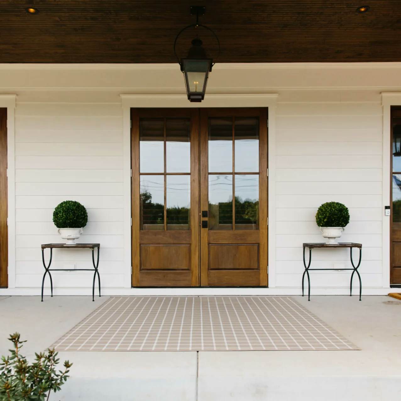 Sandpoint Beige Plaid outdoor area rug on front porch
